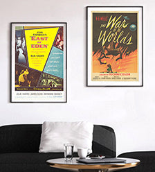 Two original movie posters (East of Eden and The War Of The Worlds) above a black sofa.